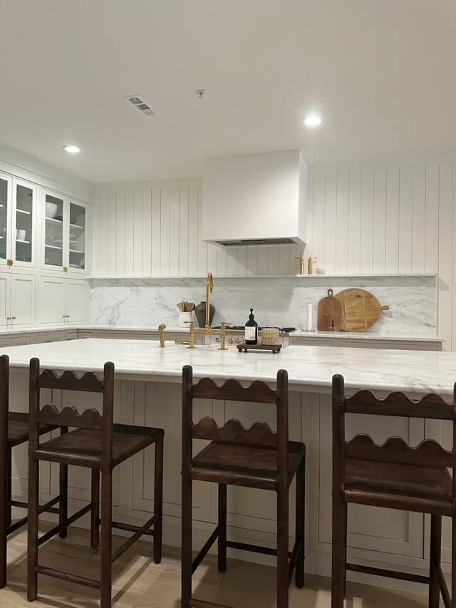 Long marble island with dark wood counter stools