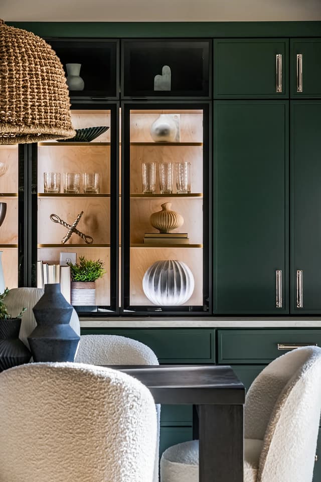 Deep green cabinetry with illuminated display storage