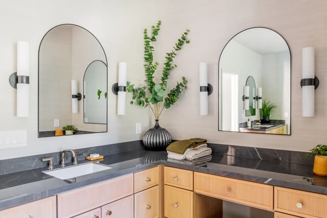 Coordinating double vanity in natural oak with dark stone counters