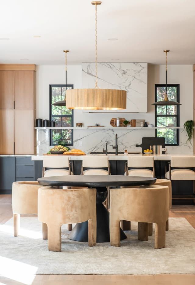 Dining table and gathering island framed by natural oak and charcoal cabinetry