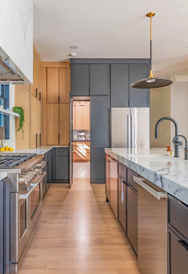 Concealed pantry entrance opened within the charcoal cabinetry