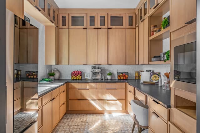 Wide view of the natural oak pantry with dark work surfaces
