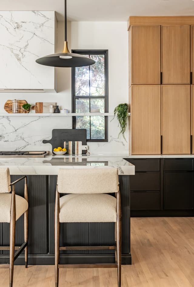 Stone-wrapped hood, natural oak towers, and charcoal island detail