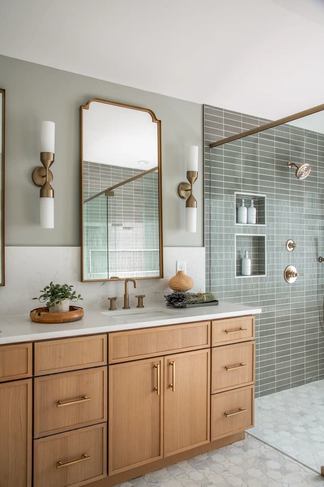 Natural oak vanity beside the glass-enclosed sage shower